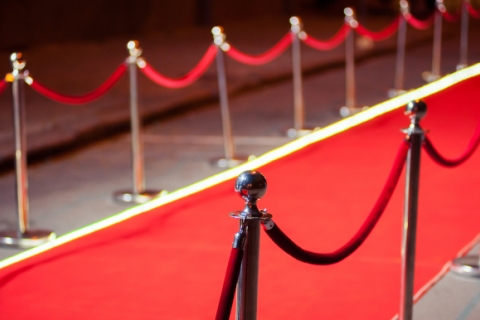 Red carpet under a spotlight with velvet ropes