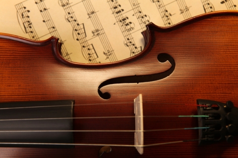 close up of a violin with sheet music