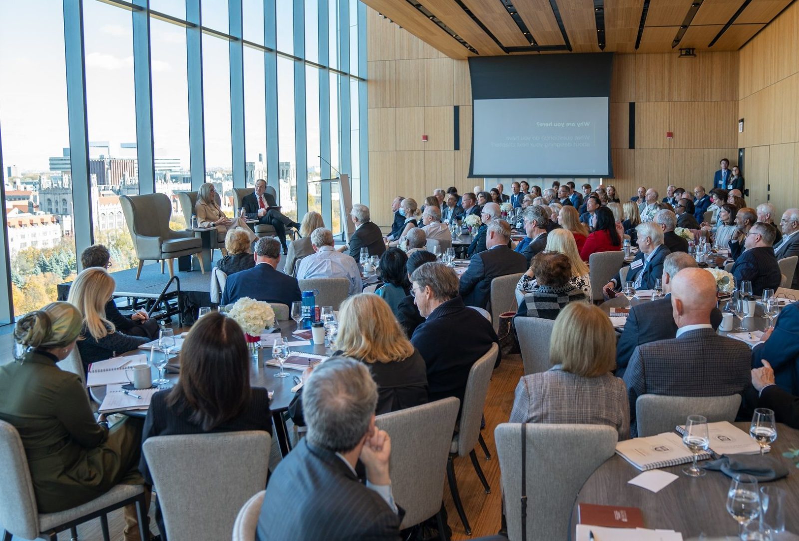 large room of people listening to two people talk